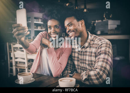 Happy young couple taking selfie in cafeteria Stock Photo