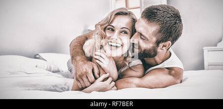 Young couple embracing on bed Stock Photo