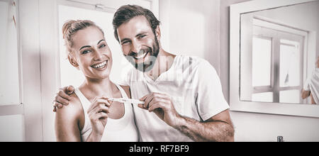 Portrait of happy couple checking pregnancy test Stock Photo