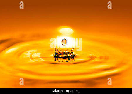 Closeup on drop of cosmetic golden oil liquid. Stock Photo