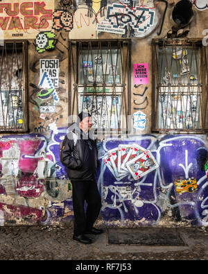 Berlin, Mitte, Street art and graffiti on brick elevated railway viaduct in Dircksenstrasse. Senior, elderly man with rucksack Stock Photo
