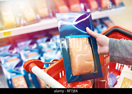 Packing of salmon fish in the hand of the buyer at the grocery store Stock Photo