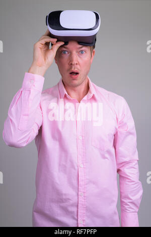 Portrait of shocked young businessman with virtual reality headset Stock Photo