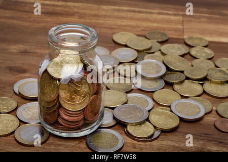 Euro coins in a money box an the table, isolated on the table Stock Photo