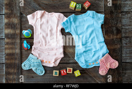 Baby clothing in pink and blue on rustic wooden background Stock Photo