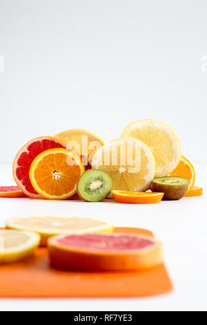 Layers of sliced fruits - kiwi, orange and grapefruits, with first plan Stock Photo