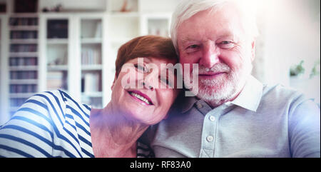 Senior couple sitting on sofa Stock Photo