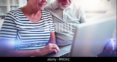 Senior couple using laptop in living room Stock Photo