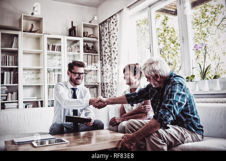 Financial advisor shaking hands with senior man Stock Photo