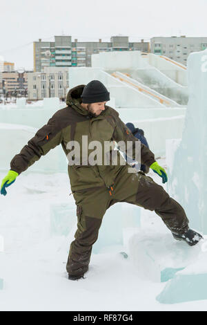 Portrait of a worker at an assembly site of an ice town in winter overalls Stock Photo