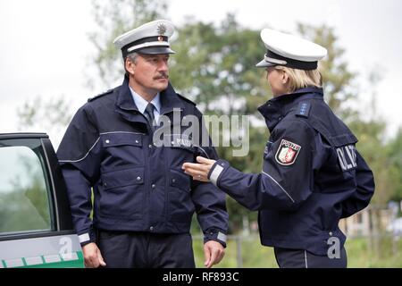 Police officers in front of a police car, new blue police uniforms worn by 1400 male and female North Rhine-Westphalian police Stock Photo