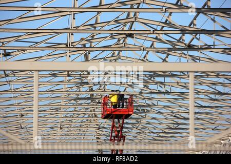 Workers on an aerial work platform (lift platform) during construction of a warehouse in Duisburg, North Rhine-Westphalia Stock Photo