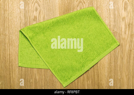 Light green towel on a beige wooden background. Stock Photo