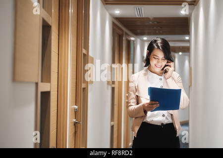 Young Businesswoman Working In Financial Agency Speaking On Cell Phone Stock Photo
