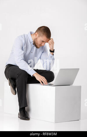 young handsome man in shirt and tie using laptop Stock Photo