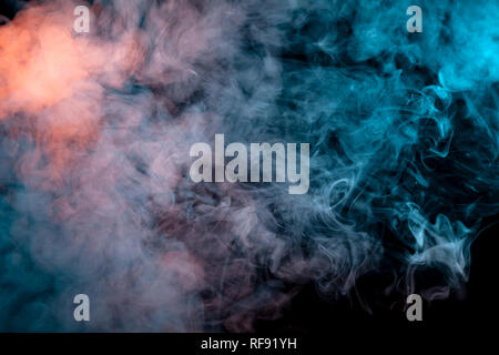Multicolored smoke from a vape of blue and purple color of the strange mystical form on on a black isolated background. Bright clouds in the abstract  Stock Photo