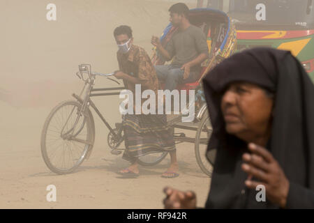 DHAKA, BANGLADESH - JANUARY 23 : Dust pollution reaches an alarming stage in Dhaka and many deaths as well as several million cases of illness occur every year due to the poor air quality in Dhaka, Bangladesh on January 23, 2019.   Dust kicked up by vehicles traveling on roads may make up 33% of air pollution. Road dust consists of deposits of vehicle exhausts and industrial exhausts, particles from tire and brake wear, dust from paved roads or potholes, and dust from construction sites. Road dust is a significant source contributing to the generation and release of particulate matter into the Stock Photo