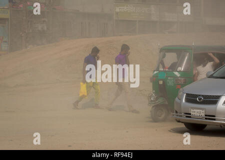 DHAKA, BANGLADESH - JANUARY 23 : Dust pollution reaches an alarming stage in Dhaka and many deaths as well as several million cases of illness occur every year due to the poor air quality in Dhaka, Bangladesh on January 23, 2019.   Dust kicked up by vehicles traveling on roads may make up 33% of air pollution. Road dust consists of deposits of vehicle exhausts and industrial exhausts, particles from tire and brake wear, dust from paved roads or potholes, and dust from construction sites. Road dust is a significant source contributing to the generation and release of particulate matter into the Stock Photo