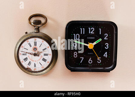 two clocks from different periods/ two watches from different eras, one with mechanical charge and one with battery Stock Photo