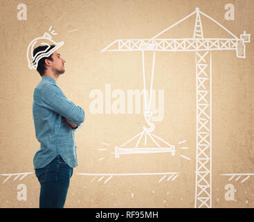 Side view portrait of a serious confident young man with crossed hands looking up imagine him as an construction engineer or a successful architect as Stock Photo