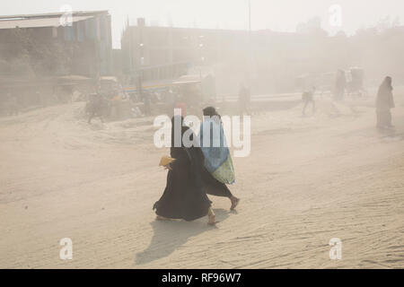 DHAKA, BANGLADESH - JANUARY 23 : Dust pollution reaches an alarming stage in Dhaka and many deaths as well as several million cases of illness occur every year due to the poor air quality in Dhaka, Bangladesh on January 23, 2019.   Dust kicked up by vehicles traveling on roads may make up 33% of air pollution. Road dust consists of deposits of vehicle exhausts and industrial exhausts, particles from tire and brake wear, dust from paved roads or potholes, and dust from construction sites. Road dust is a significant source contributing to the generation and release of particulate matter into the Stock Photo