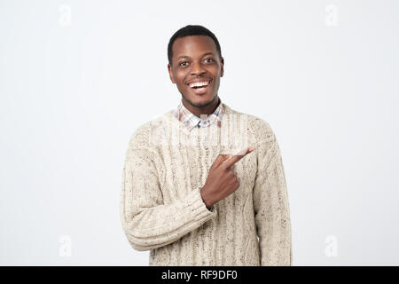Look over there. Happy young handsome african man pointing away and smiling Stock Photo