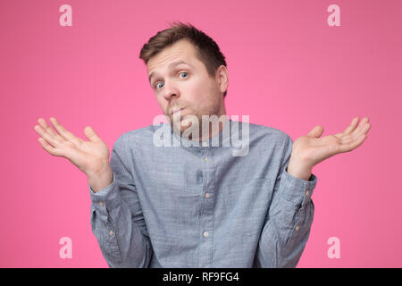 So what, Who cares. Unsure doubtful man shrugging his shoulders in questioning gesture Stock Photo