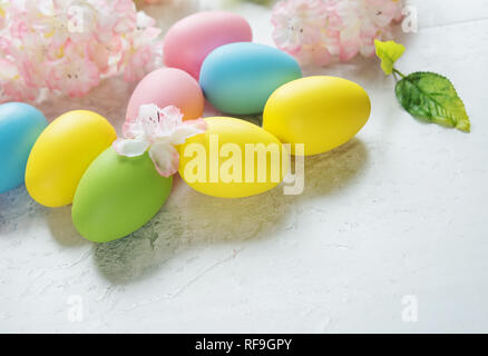 Beautiful delicate Easter composition with pink cherry flowers and multicolored Easter eggs Stock Photo