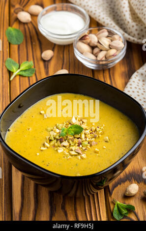 Vegetable cream lentil soup, pumpkin, pistachio and mint, tasty dish Stock Photo