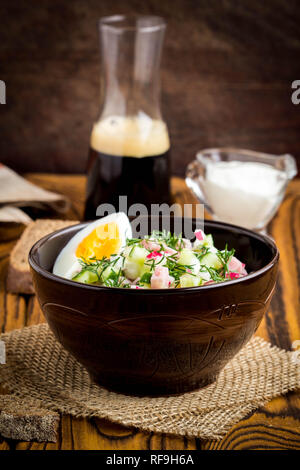 Traditional summer Russian cold soup with kvass, okroshka with ham and vegetables, food Stock Photo