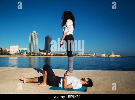 Beautiful couple practicing acro yoga in the morning Stock Photo