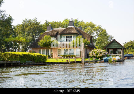 The thatched roof house with beatiful garden in fairytale village Giethoorn in The Netherlands. Stock Photo