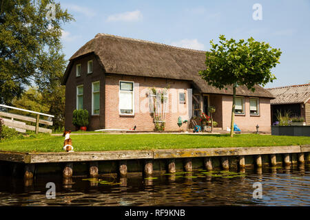 The thatched roof house with beatiful garden in fairytale village Giethoorn in The Netherlands. Stock Photo