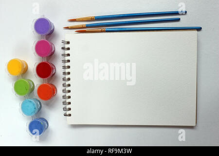 Blank spiral notebook with paint pots and paint brushes Stock Photo
