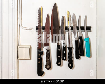 kitchen knives on magnetic holden on wall Stock Photo