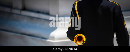 A US Army bugler stands at attention and ready to sound taps at a cemetery in Virginia. Stock Photo