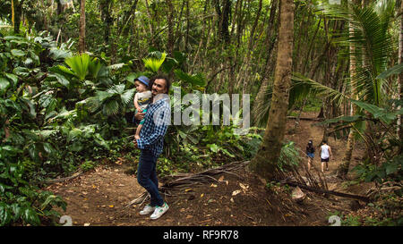 A photo of a man and his son walking in the tropical rain forest of the beautiful Manzanillo National Park, Costa Rica. Stock Photo