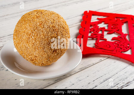 traditional Chinese fried sesame ball with a label on back English translation of Chinese-happy new year Stock Photo