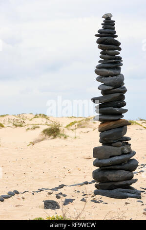 Cairn made of Black Volcanic Pebbles on a Beach on the Southern Coast of the Island of Boa Vista, Cape Verde Islands, Africa. Stock Photo