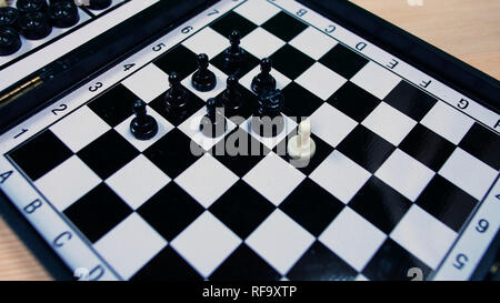 white chess pieces lined up against all black pawns, ideal footage to represent problems of integration, violence and racism Stock Photo