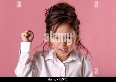 angry little child girl in white shirt with hairstyle Stock Photo