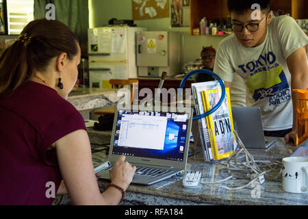 A photo of a female biology teacher and her student working on their laptops. Taken in a science class. Stock Photo