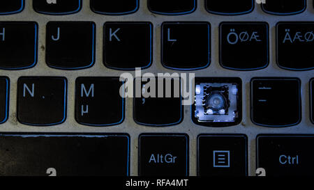 A photo of a backlit Laptop keyboard that is missing the dot (point) key (button) Stock Photo