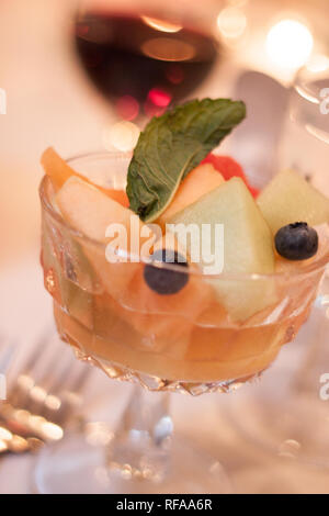 Dessert fruit salad in a crystal serving glass, at a formal dinner event, specifically a wedding reception. Stock Photo