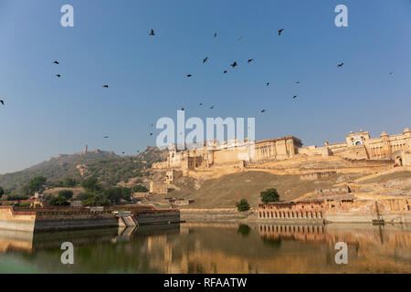 Amber Fort illuminated by warm light of the rising sun and reflected in the lake. Famous Rajasthan landmark located nearby Jaipur city in north-wester Stock Photo