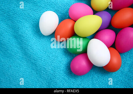 Multi colored easter eggs against a bright blue wool blanket background. Stock Photo