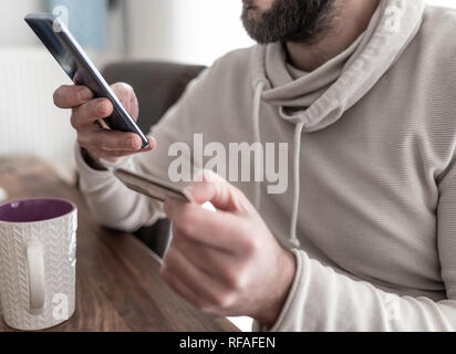 man entering credit card information on smartphone Stock Photo