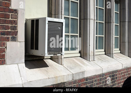 Window Air Conditioner unit on old brick building Stock Photo