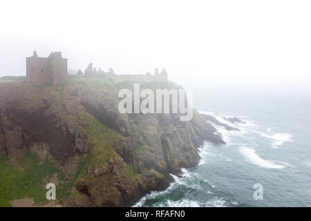 Dunnottar Castle in the mist, ruined medieval fortress near Stonehaven on sea cliff along the North Sea coast, Aberdeenshire, Scotland, UK