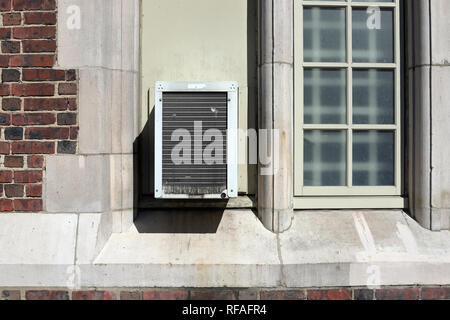 Window Air Conditioner unit on old brick building Stock Photo